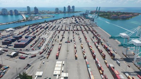 Miami Port, June 2019. Hyper lapse above harbor dock revealing panoramic view on cargo port with Miami Beach and Atlantic ocean on background. Freight containers, import and export business 4K USA