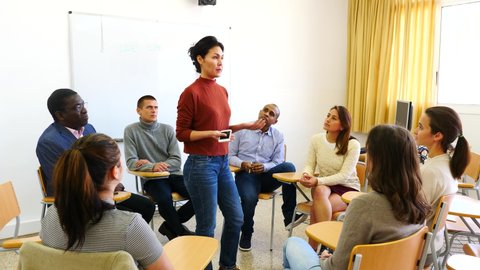 Female teacher is giving lecture for students in the class. High quality 4k footage