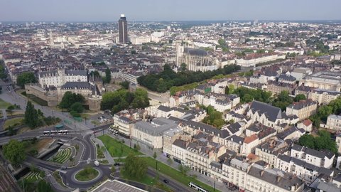 Drone view of ancient Chateau des ducs de Bretagne and Nantes Cathedral on background of downtown with modern skyscraper in summer, France