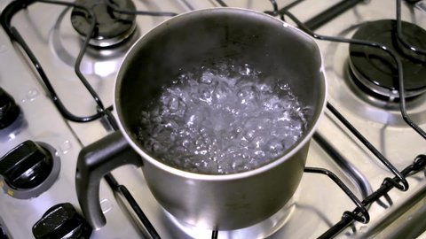 water being put into pot on the stove in slow motion
