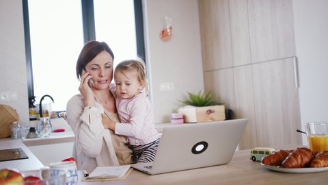 Mother working at home, playing with daughter. Homeoffice concept.