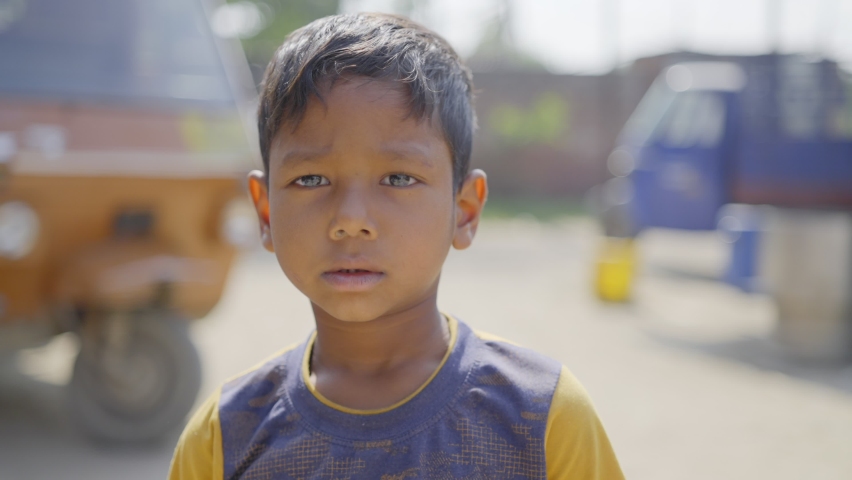 outdoor close up shot of a young cute Indian Asian little male kid standing in a broad daylight looking at the camera Royalty-Free Stock Footage #1068763454