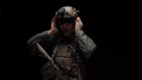 Special forces US soldier puts on his helmet in the dark