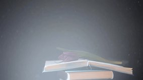 footage of books flower dust dark background 