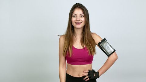 Young caucasian woman with sports clothes pointing to the side and presenting a product while smiling over isolated background
