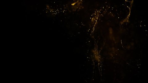 Golden glitter sand or dust creating abstract cloud formations metamorphosis. Art backgrounds. gold ink in water shooting with high speed camera. Super Slow Motion at 1000fps.