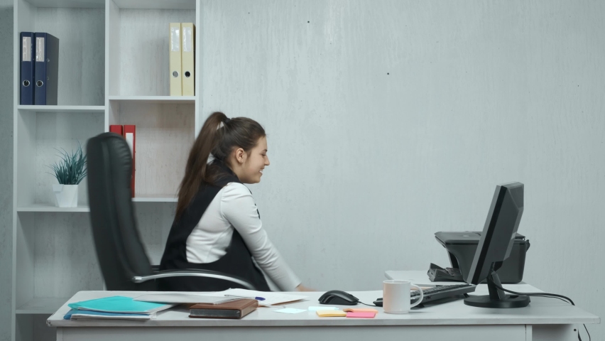 The girl is having fun in the office. A carefree, excited employee is happily rolling around on a chair. Leisure in the office, rest during the working day. | Shutterstock HD Video #1068798905