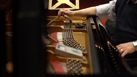 Detail view of sound master hand tuning a piano, Close view of technician calibrating piano strings, Man hand adjusting piano sounds, 4k sound master tuning piano strings
