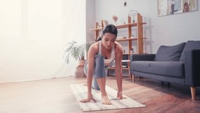 Barefoot sportswoman stretching leg during workout at home