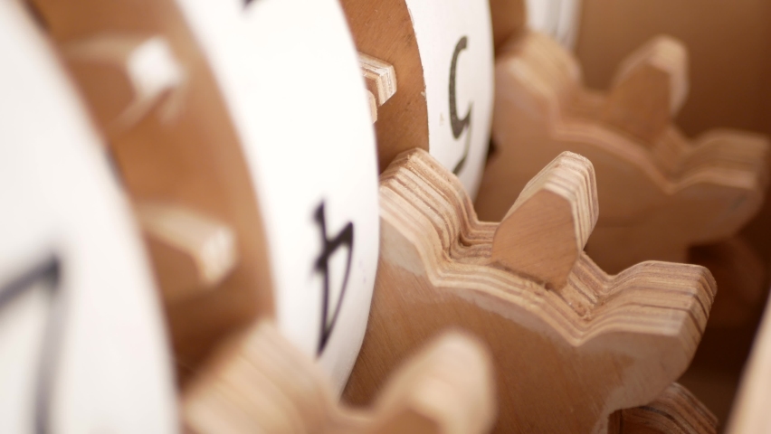 Wooden mechanism with gears. Counter with numbers on the reels. Switch the next digit.
