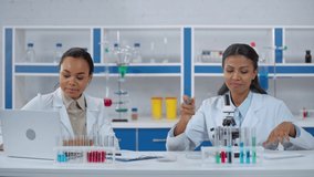 African american scientists in white coats working in laboratory