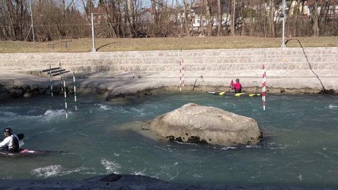 TACEN, SLOVENIA. 2.3.2020. Athletes paddling up the river in canoes. Professional athletes training canoe slalom between poles in white water rapids 