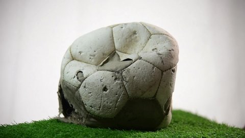footage of damage soccer ball rotate on green artificial grass