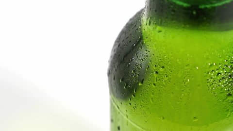drops flow down the cold green glass of the bottle on a white background. chilled beer and drinks in the heat of summer. Refrigerator. condensate. close up.