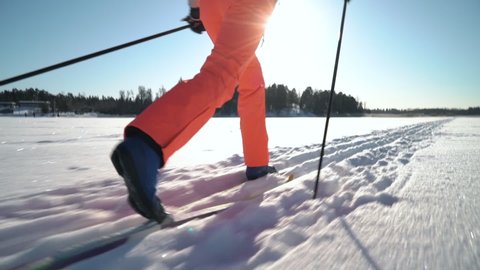 A woman going cross-country skiing on a frozen bay in Finland on a frosty sunny day. Steadicam Tracking Shot.