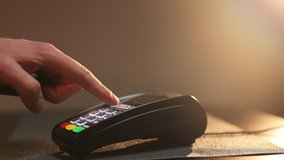Close up hands of man making payment with credit card machine terminal while swiping debit card to pay the bill. Man hand enters the credit card pin to make the payment through terminal pos. - Powered by Shutterstock - Get 15% off with code: PIKWIZARD15