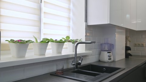 Panorama of modern small minimalistic classic luxury white and grey kitchen interior, rack focus technique, utensils or silverware drawer are pulled out