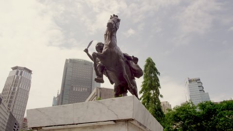 MANILA, PHILIPPINES - MARCH 9, 2013: Statue of Filipina Revolt Leader Gabriela Silang in Background the Hi Rise Buildings of Ayala Ave