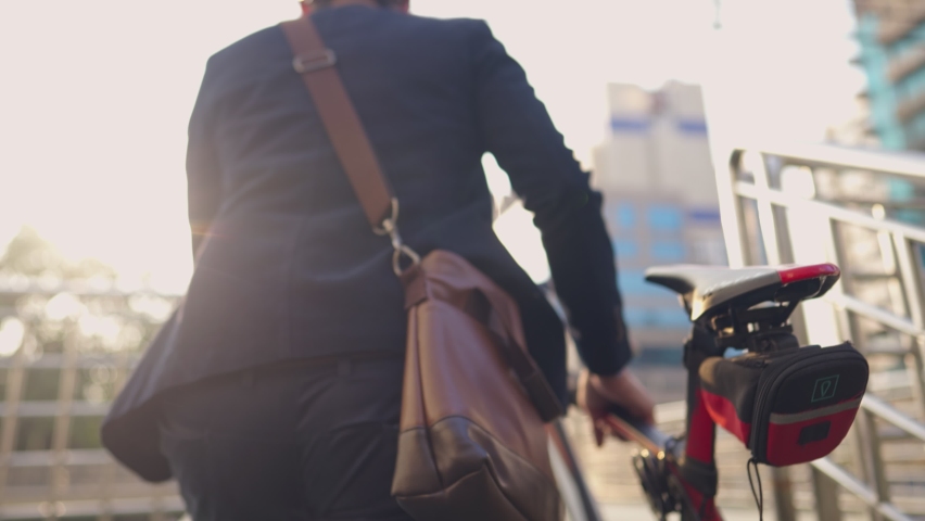 Young active employee in formal suit with helmet on head pushing up his bike to overpass across traffic jam in rush hour, cyclist traveling by sustainable transport and living a healthy lifestyle Royalty-Free Stock Footage #1068833522