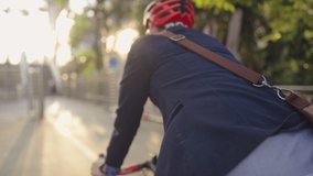 Confident male worker in formal cloths with a crossbody bag commuting by bicycle to workplace, smart handsome cyclist traveling by sustainable transport and living a healthy lifestyle, green energy