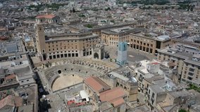 Lecce,Puglia,Italy Beautiful panoramic aerial 4K video from flying drone to Roman Amphitheatre, arena Lecce. Historic city center, Cathedral of Maria Santissima Assunta, on a beautiful summer day.