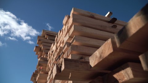 Stock of Lumber. Rafters for building a house. Packs of lumber at the Sawmill. Big framework. Natural materials from wood. Knots on Lumber. Pine Boards in large packages. Manufacture of wooden product