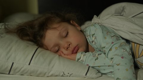 Cute little kid girl sleeping well alone in bed. Close up