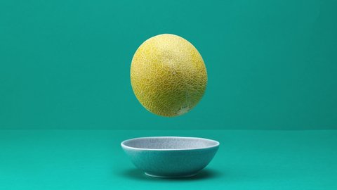 fresh ripe melon rolling and jumping on turquoise background. rotating plate of melon slices. stop motion animation