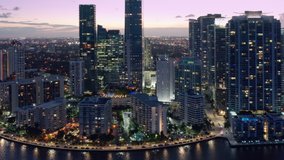 Establishing aerial view shot of Miami downtown skyline. Modern architecture waterfront skyscraper glass buildings in foreground, Miami city in background. USA Florida sunset dusk purple colors of sky