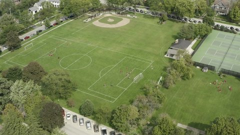 Aerial view of a suburban playfield with baseball diamonds, tennis courts and soccer fields.
