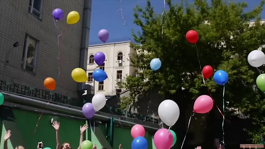 Balloons in the sky.Kindergarten celebrates its anniversary. Children took to the streets with a beautiful balloon. After congratulations - all the guests and children released balloons into the sky. Royalty-Free Stock Footage #10688732