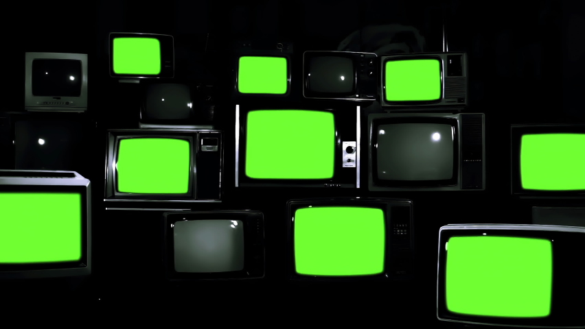 Nine Vintage Televisions turning on Green Screens on a Retro TV Wall. Dark Tone. Zoom In. 4K Resolution. Royalty-Free Stock Footage #1068874175
