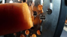 carrot on a grater, macro video, camera moves up and down, vegetable dish