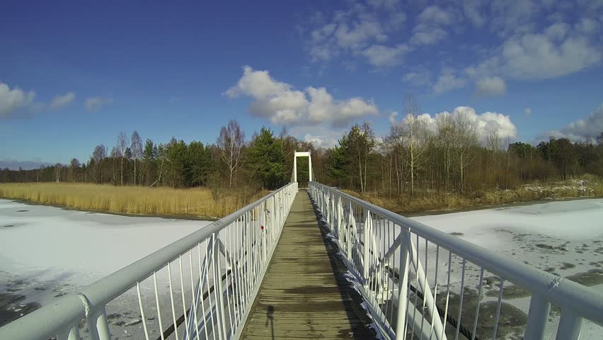 Winter landscape with bridge above frozen river
