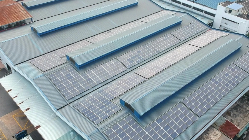 Aerial top down view of factory building with solar panels on roof providing the factory with renewable energy from the sun  Royalty-Free Stock Footage #1068883382