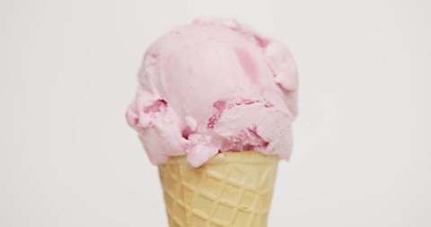 Time Lapse Ice cream Strawberry scoop in waffle cone on white background.