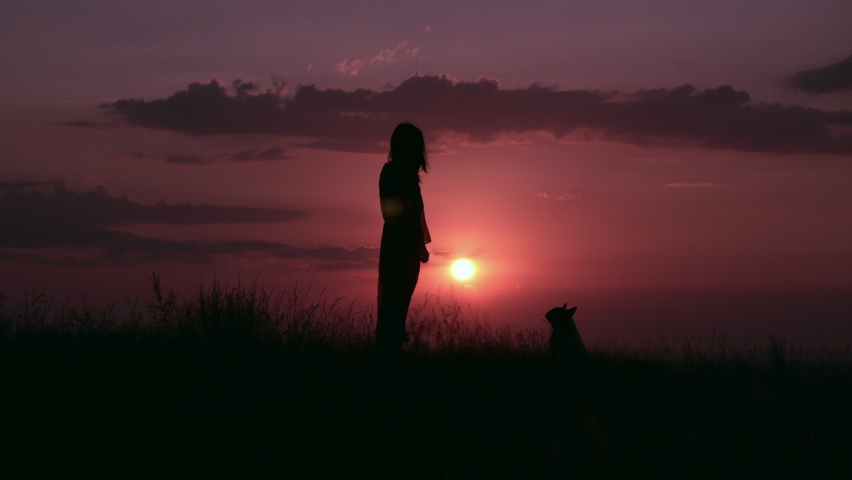 silhouette woman with dog standing on the hill amazing sky view