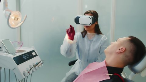 Female dentist looking at BP glasses x-ray of patient. Modern dentistry. Dentistry with virtual reality.