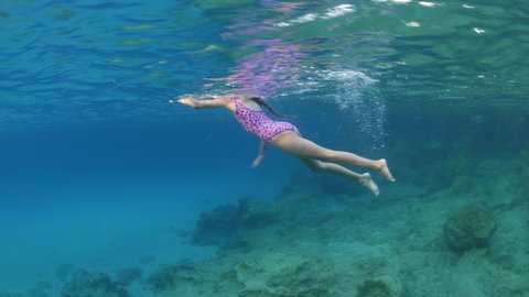 swimming little girl  enjoying water diving sun beams sun rays underwater summer holiday