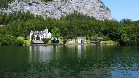 Summer rural landscape with lake and white house in Hallstatt, Upper Austria. European alps and Hallstatter lake in Salzkammergut region