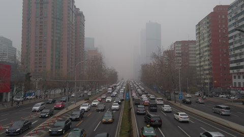 Beijing, China - Mar4, 2021: Cars driving on Guomao road, Central Business District on smoggy day.