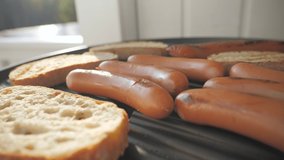 The barbecue grill with the frankfurter and toast bread on top during a breakfast party at home.4k