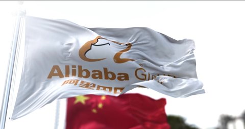 Hangzhou, China, march 12 2021: Flag with the Alibaba Group logo flying along with the national flag of China. Alibaba is a Chinese multinational technology company. Business and financial concept.