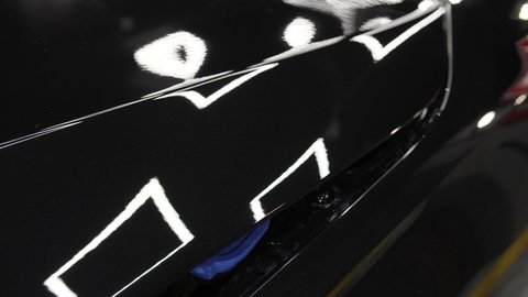 Black car hood after polishing. Close up view of hood car. Process of polishing auto.