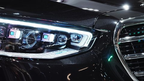 Headlights of the newest Mercedes-Benz S-Class W223. Modern technology of digital laser LED optics at a prestigious car. Closeup cinematic 4k shot. Moscow, Russia - March, 2021.