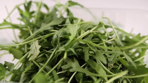 green arugula salad drops on white table