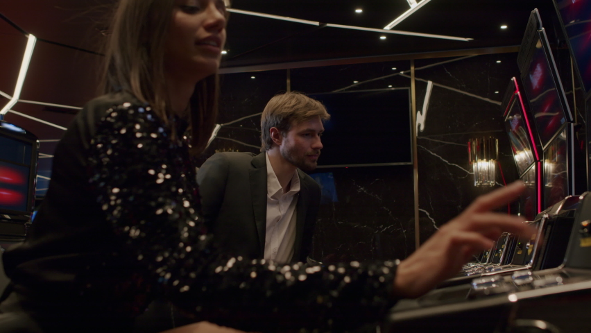friends or couple enjoying playing the slot machine at the elite casino. Gambling, nightlife