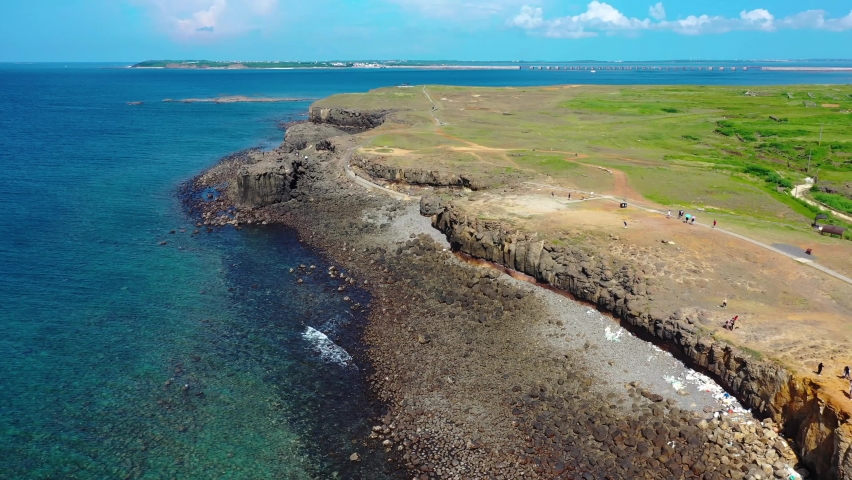 Aerial travelling over the cliffs above the beach in Magong, Penghu Island, Taiwan. Royalty-Free Stock Footage #1068915620