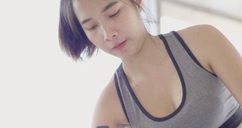 Face close up Asian woman bicep muscle warm up workout weight training and yoga exercise at home in sexy sportswear. Take care health in quarantine coronavirus with new normal social distancing