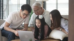 Modern family Asian daughter using laptop with her parents watching applications and enjoying with laptop together. Modern life family with smart house daughter and parents enjoying with laptops.